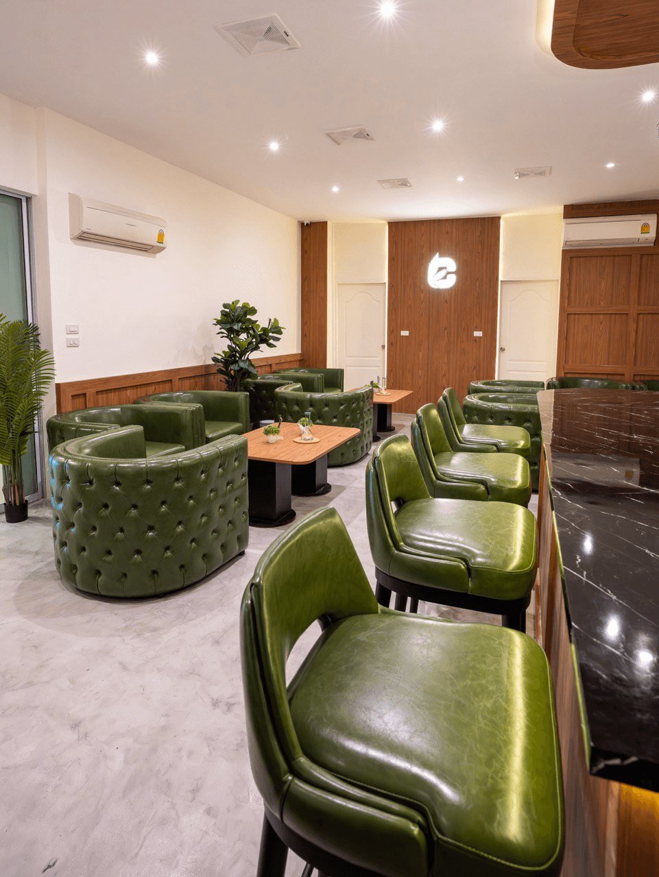 Customer lounge with green armchairs at CannaBuri, Pattaya