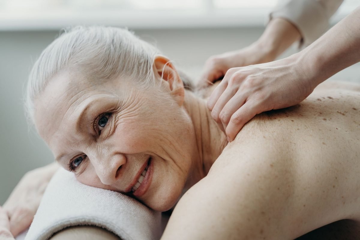 Smiling older woman relaxing during a back treatment