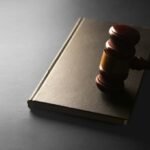 A wooden gavel resting on a closed law book, illustrating Thailand's draft Cannabis Control Bill